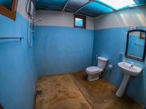 Un baño azul con inodoro y lavabo. en Hello Super Hostel, en Ella