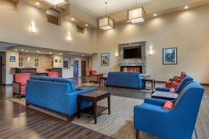 a lobby with blue furniture and a fireplace at Comfort Inn & Suites Near Mt Rushmore in Hill City