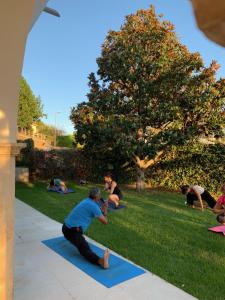 un grupo de personas haciendo yoga en la hierba en Montjuic Boutique Bed & Breakfast Girona en Girona