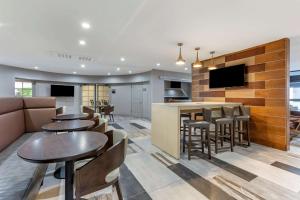 a restaurant with tables and a bar with a tv at Windmill Suites Surprise, Ascend Hotel Collection in Surprise