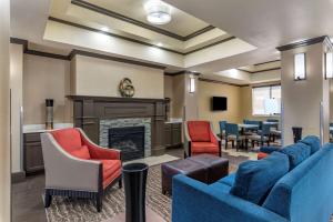 una sala de espera con sillas azules y chimenea en Comfort Inn & Suites El Dorado, en El Dorado
