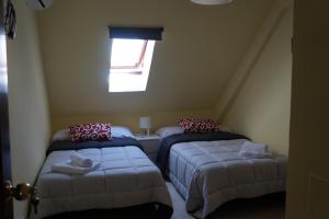 Zimmer im Dachgeschoss mit 2 Betten und einem Fenster in der Unterkunft Apartamento Centro Pergo in Córdoba