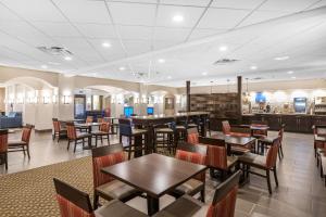 a dining room with tables and chairs in a restaurant at Comfort Inn & Suites Allen Park - Dearborn in Allen Park
