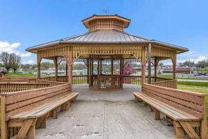 a wooden gazebo with benches in a park at Econo Lodge in Cameron