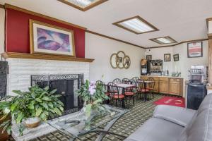a living room with a fireplace and a table and chairs at Econo Lodge Cameron in Cameron