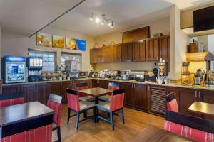 a kitchen with wooden cabinets and a table and chairs at Comfort Inn Marshall Station in Marshall