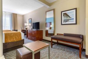 a hotel room with a bed and a tv at Comfort Suites Southport - Oak Island in Southport