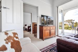 a living room with a couch and a tv at Bridport Beach House in Bridport