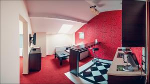 Habitación con escritorio y habitación con paredes rojas. en Euphoria Residence, en Sosnowiec