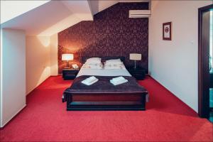 a bedroom with a large bed with red carpet at Euphoria Residence in Sosnowiec
