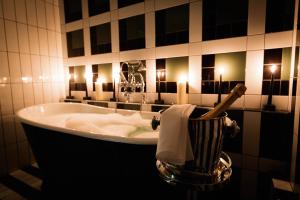 a bathroom with a bath tub with candles in it at Malmaison Birmingham in Birmingham