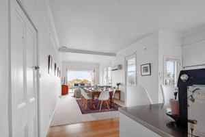 a kitchen and dining room with white walls and a table at Bridport Beach House in Bridport
