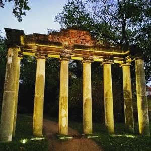 une structure en pierre avec des colonnes dans un parc dans l'établissement Ziebigk Appartement Deluxe, à Dessau