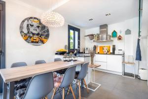 eine Küche und ein Esszimmer mit einem Holztisch und Stühlen in der Unterkunft Villa 11 Oasis del Mare, 5min Strand, Wifi, Klima, Fußbodenheizung in Sa Ràpita