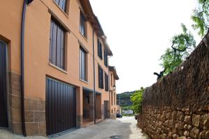 eine Gasse mit einem Gebäude und einer Steinmauer in der Unterkunft Casa Mallos de Agüero in Agüero