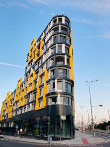 ein gelbes und schwarzes Gebäude in einer Stadtstraße in der Unterkunft Apartement Blanc Harfa design in Prag