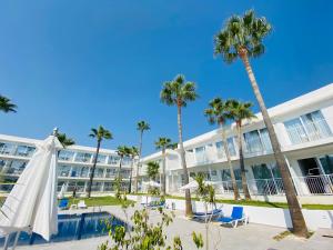 a hotel with palm trees and a pool at Lysithea Hotel in Larnaka