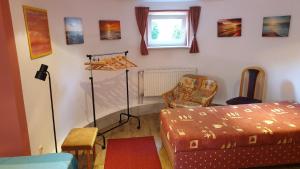 ein Schlafzimmer mit einem Bett, einem Stuhl und einem Fenster in der Unterkunft Zimmervermietung Koltermann in Greifswald