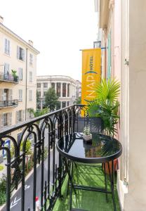a table on the balcony of a building at Hotel Nap By HappyCulture in Nice