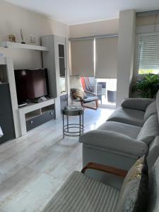 a living room with a couch and a tv at Luxury Apartamento Minerva Júpiter in Benalmádena