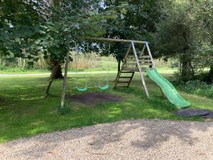 une aire de jeux avec un toboggan et une balançoire dans l'établissement Riverside log cabin, à Ballyconnell