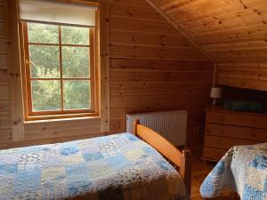 ein Schlafzimmer mit einem Bett und einem Fenster in einer Hütte in der Unterkunft Riverside log cabin in Ballyconnell