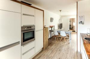 a kitchen with white cabinets and a table with white chairs at Diemer 6 in Groningen