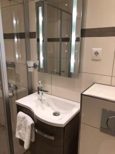 un baño con lavabo y espejo en Appartement Ausblick Park, en Hahnenklee-Bockswiese