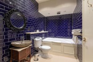a blue tiled bathroom with a toilet and a sink at The Coal Exchange Hotel in Cardiff +58 photos
