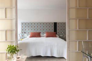 a bedroom with a large white bed and shelves at Eric Vökel Boutique Apartments - Copenhagen Suites in Copenhagen