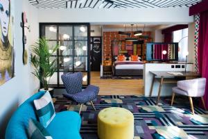 a living room with a blue couch and a bedroom at Malmaison Manchester in Manchester