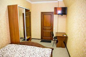 a bedroom with a bed and a desk and a mirror at Готель-ГАЙСИН-Ресторан in Haysyn