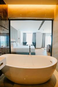 bañera grande en una habitación con dormitorio en Klajdi Resort & SPA, en Golem