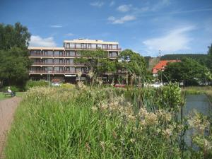 a large building next to a body of water at Appartement Ausblick Park in Hahnenklee-Bockswiese