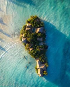 an island in the ocean with people on it at The Island - Pongwe Lodge in Pongwe