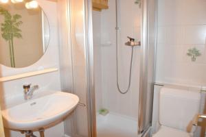 uma casa de banho com um chuveiro, um lavatório e um WC. em Botzatei 001 em Verbier