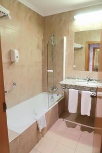 
a bathroom with a shower, sink, and tub at Hotel Gudamendi in San Sebastián
