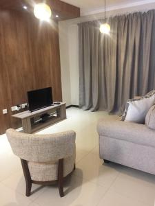 a living room with a couch and a table with a laptop at Lifestyle Apartments in Gaborone