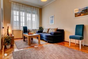 a living room with a couch and a table and chairs at Apartman Tara in Belgrade