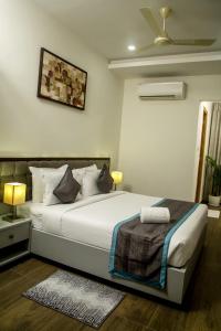 a bedroom with a large white bed with a ceiling at PARK IRIS HOTELS, MG Road in Vijayawāda