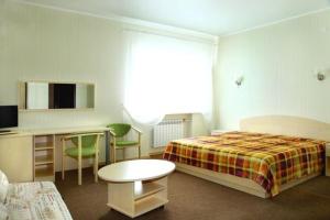 a bedroom with a bed and a desk and a table at Hotel Rus in Oryol