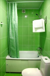 baño de azulejos verdes con bañera y aseo en Hotel Rus, en Oriol