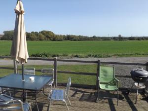 a patio with a table and chairs and an umbrella at Avonvale Holiday Lodges in Evesham
