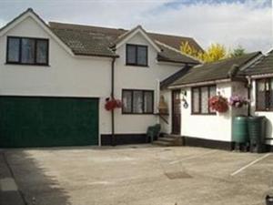 Casa blanca con garaje verde en Spreyton Guest House, en Weston-super-Mare