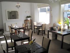 a dining room with tables and chairs and a window at Spreyton Guest House in Weston-super-Mare
