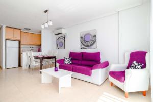 ein Wohnzimmer mit einem lila Sofa und einem Tisch in der Unterkunft 095 Apartamento ELITE in Torrevieja