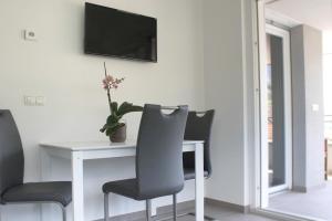 a table with two chairs and a television on a wall at CasaLuNa in Appiano sulla Strada del Vino