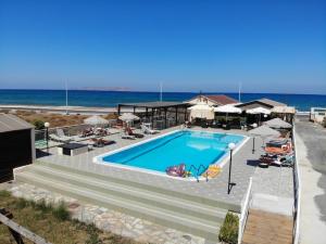 a swimming pool with the ocean in the background at Divina Seaside Apartments by Estia in Gouves