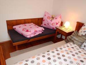 a bedroom with two beds with pink pillows on a bench at Haus Berauer in Fieberbrunn