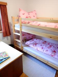 a bedroom with two bunk beds with pink sheets at Haus Berauer in Fieberbrunn